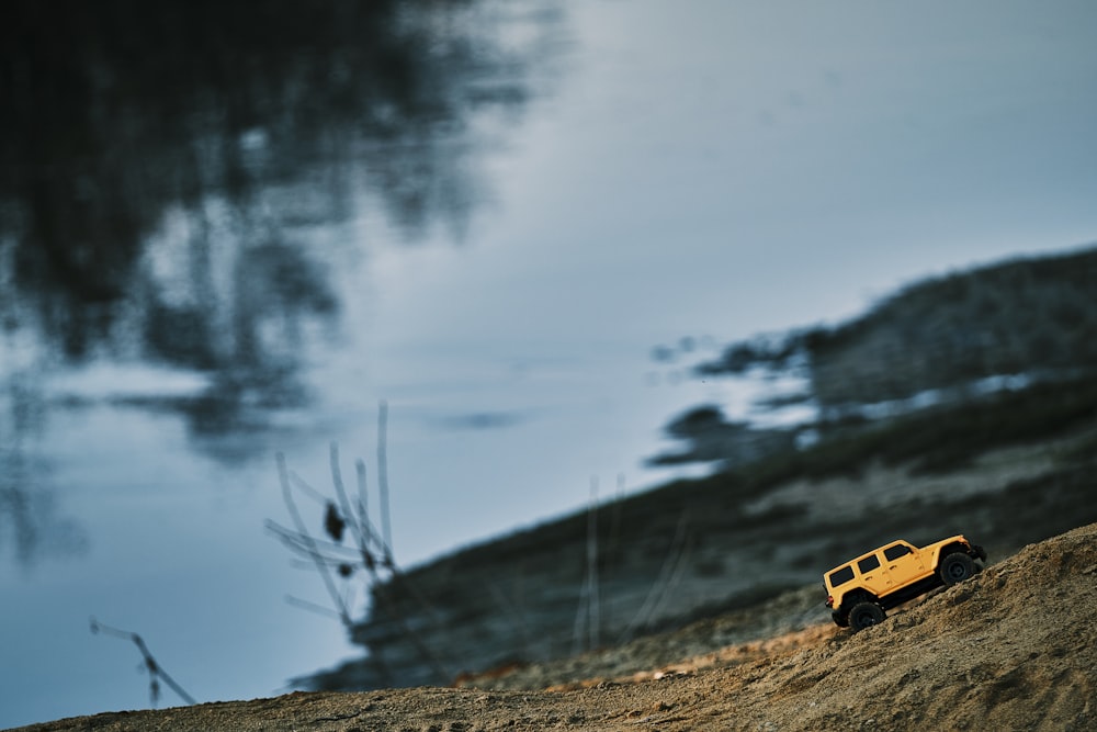 a yellow truck is parked on the side of a hill