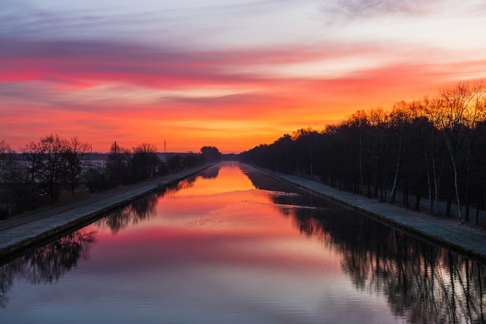 a long canal with a sunset in the background