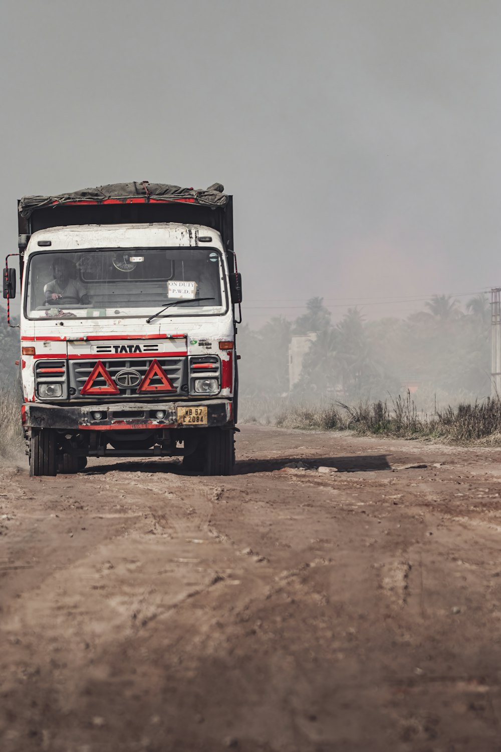 a white truck driving down a dirt road