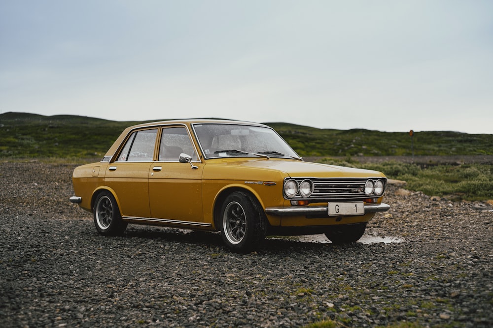 a yellow car parked on a gravel road