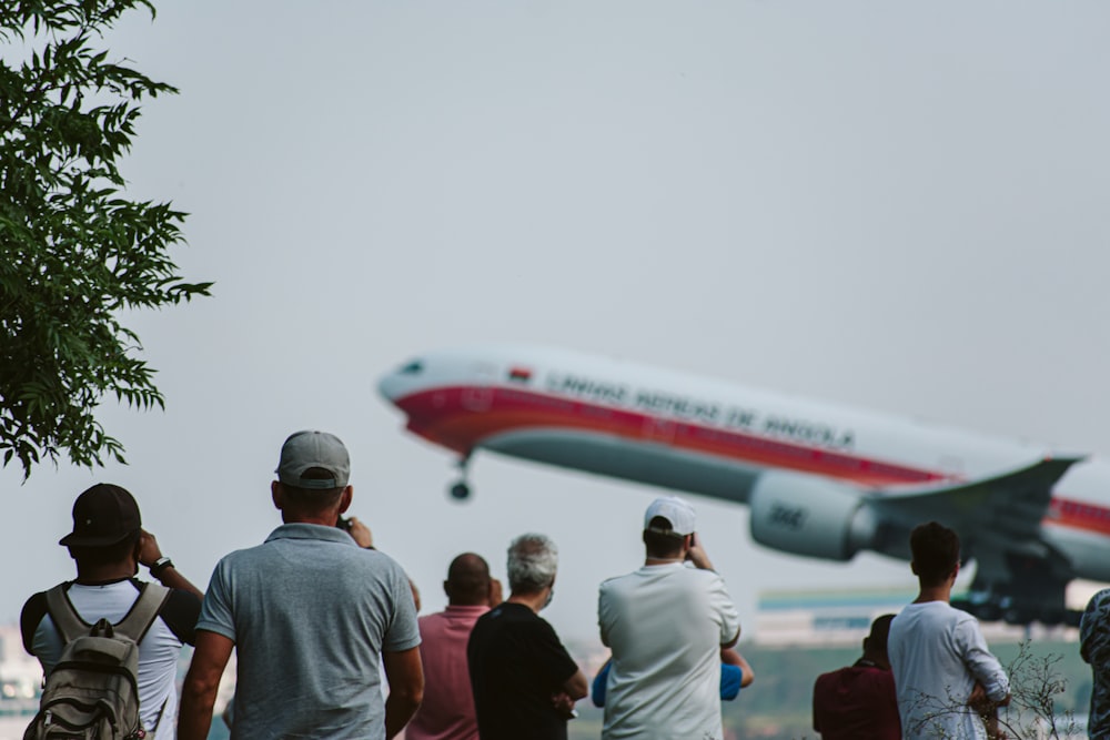 飛行機が離陸するのを見ている人々のグループ