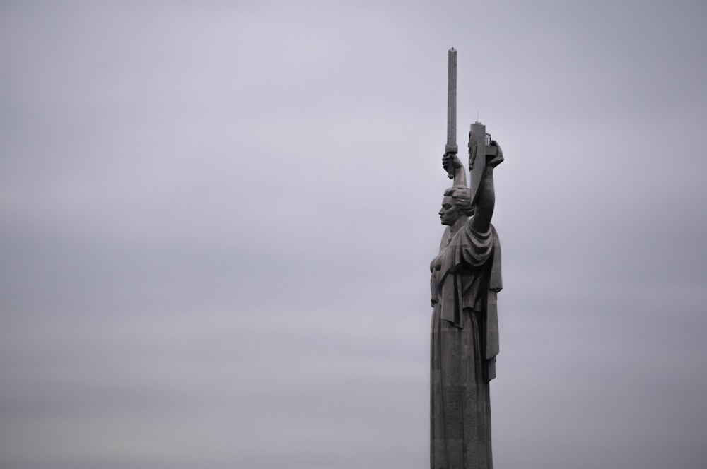 a statue of a person holding a cross