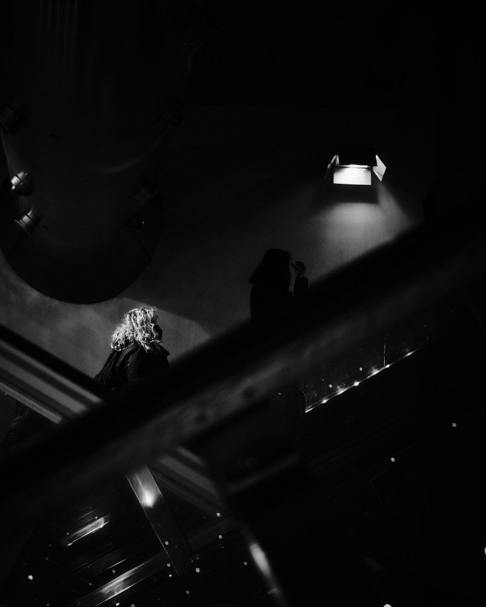 a black and white photo of a woman in a dark room