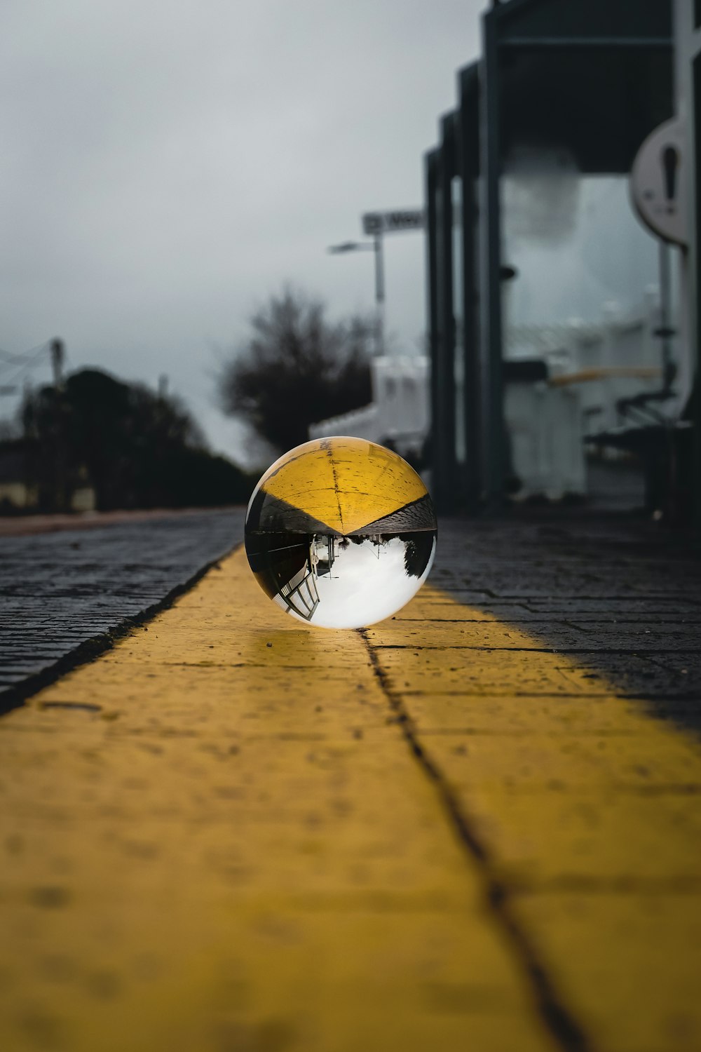 a yellow and black street light sitting on the side of a road