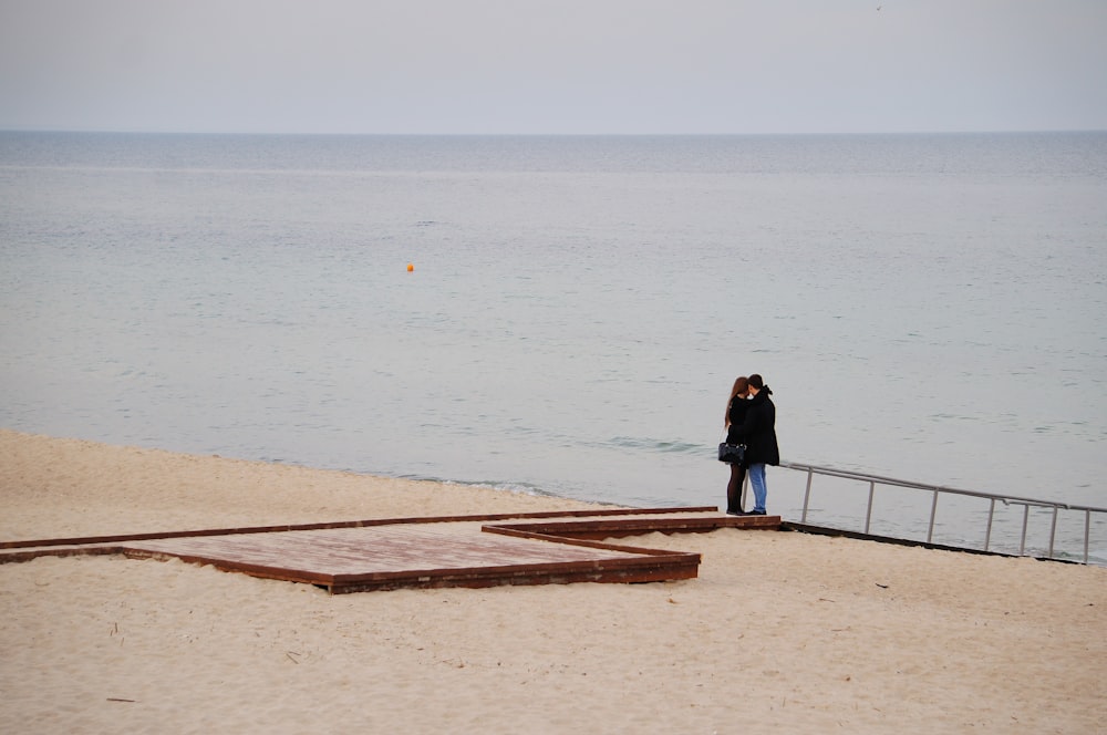 a woman standing on a beach next to the ocean