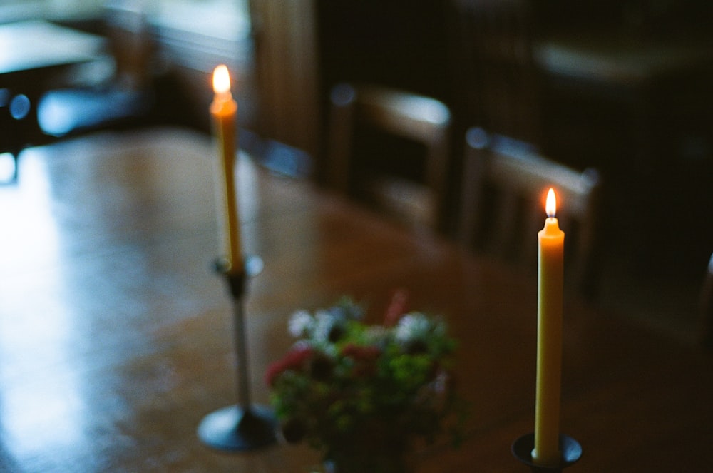 Un par de velas sentadas encima de una mesa de madera