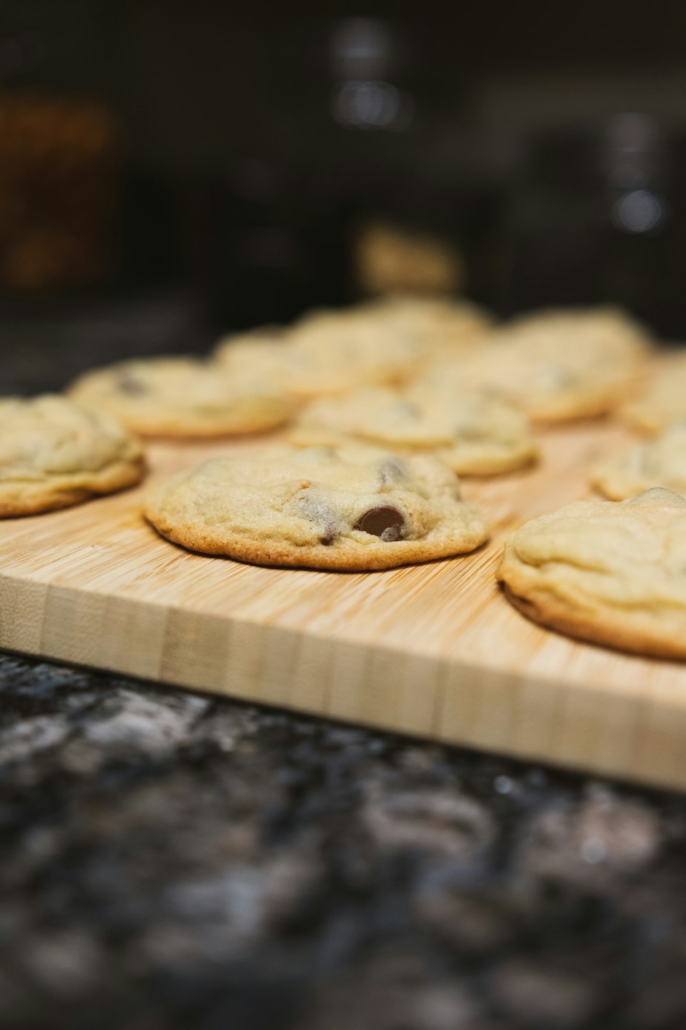 a wooden cutting board topped with cookies on top of a counter