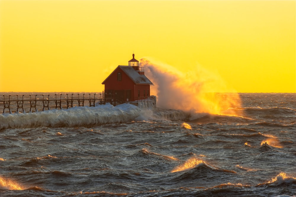 a red house in the middle of a large body of water