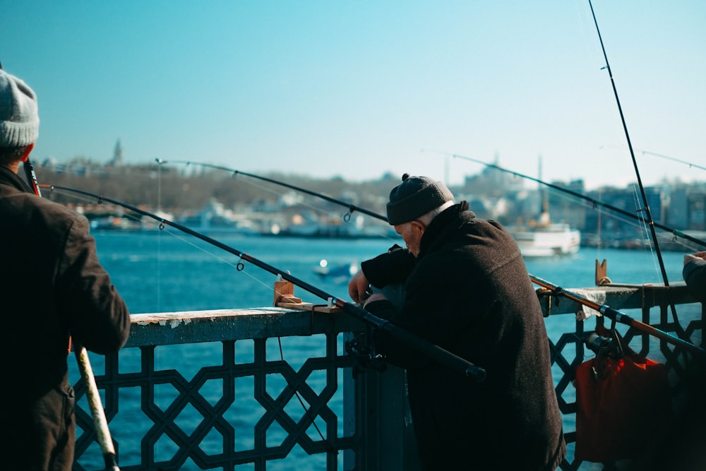 a couple of men standing next to each other on a bridge