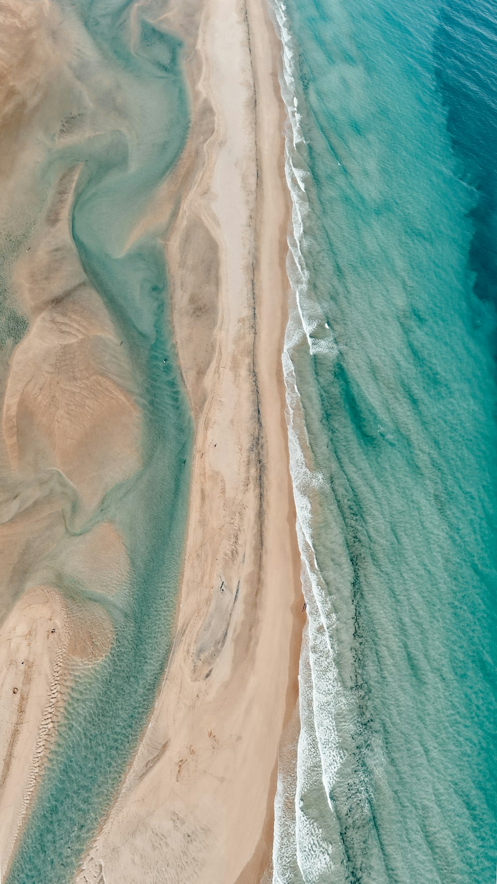 an aerial view of a sandy beach and ocean