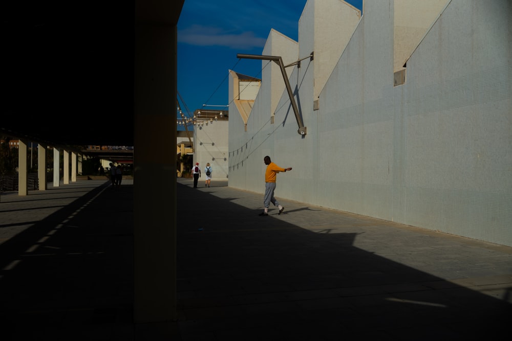 a man riding a skateboard down a street next to a tall building