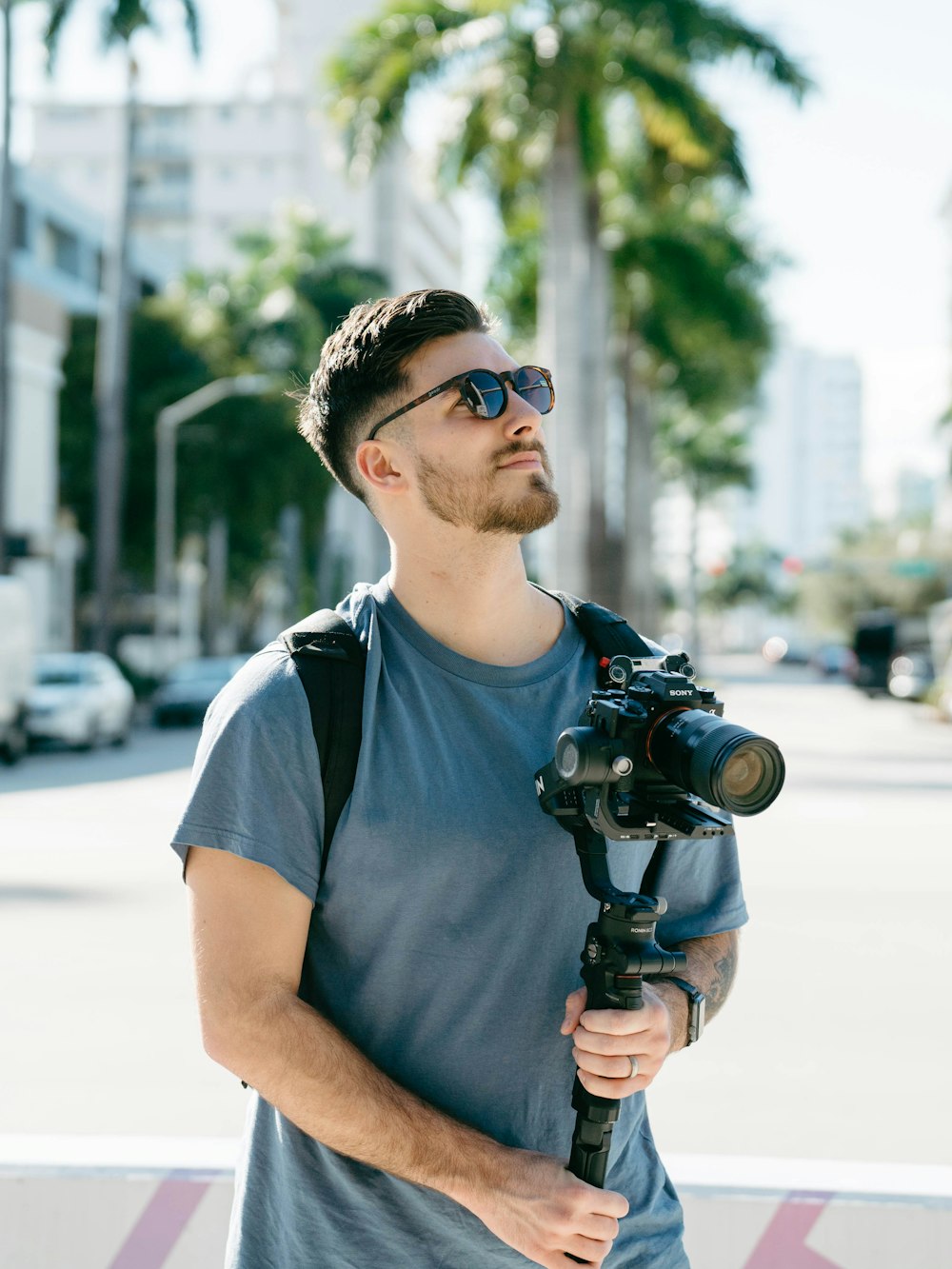 a man holding a camera and a tripod