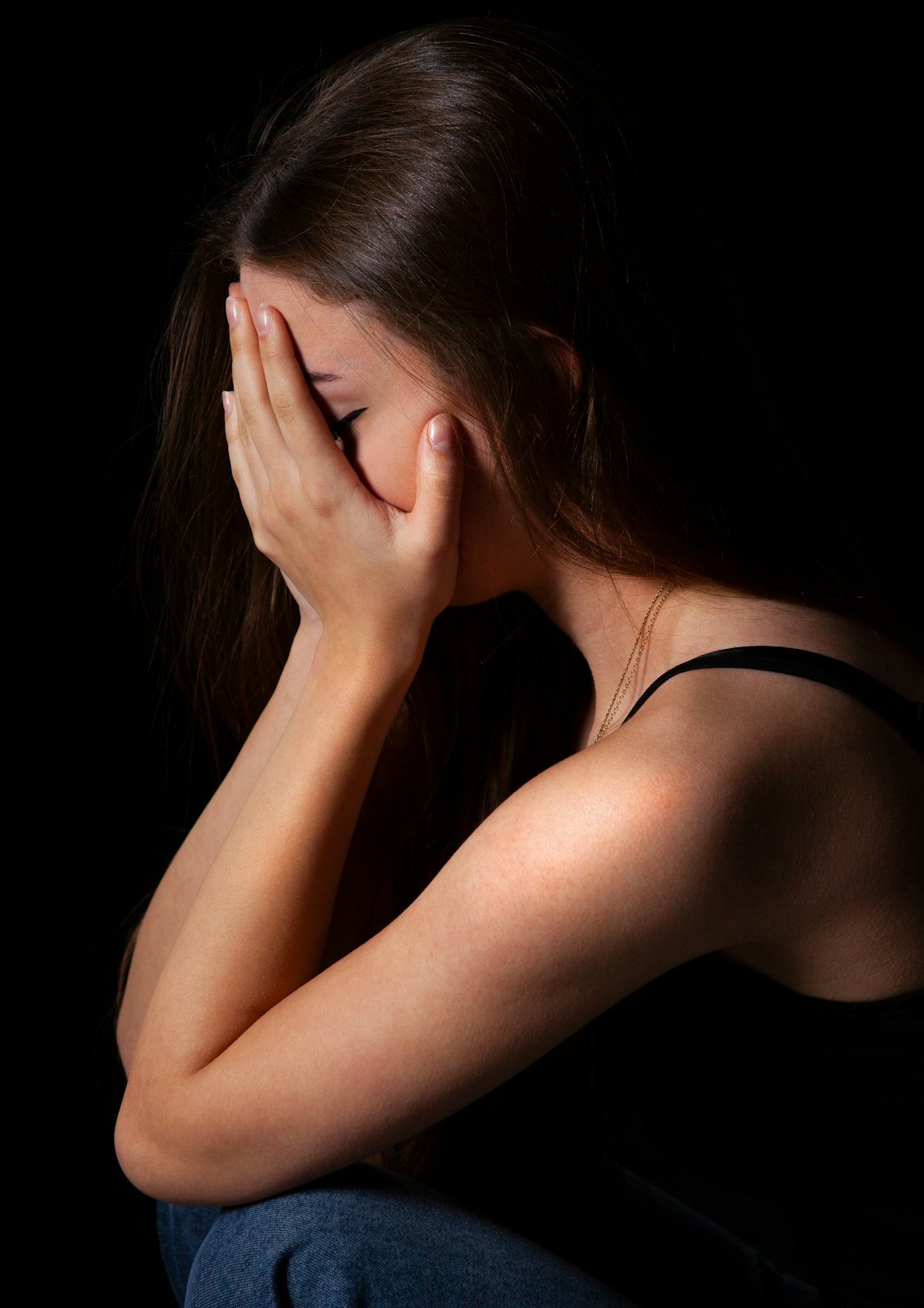 Woman resting her face in her hand, asking why do I feel guilty when someone is upset with me