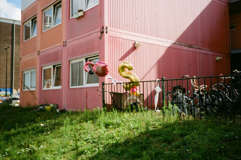a pink building with a bunch of balloons in front of it
