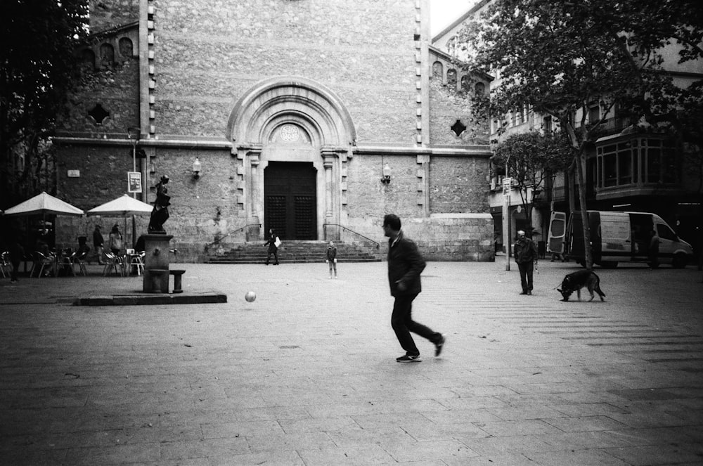 a black and white photo of a man playing soccer