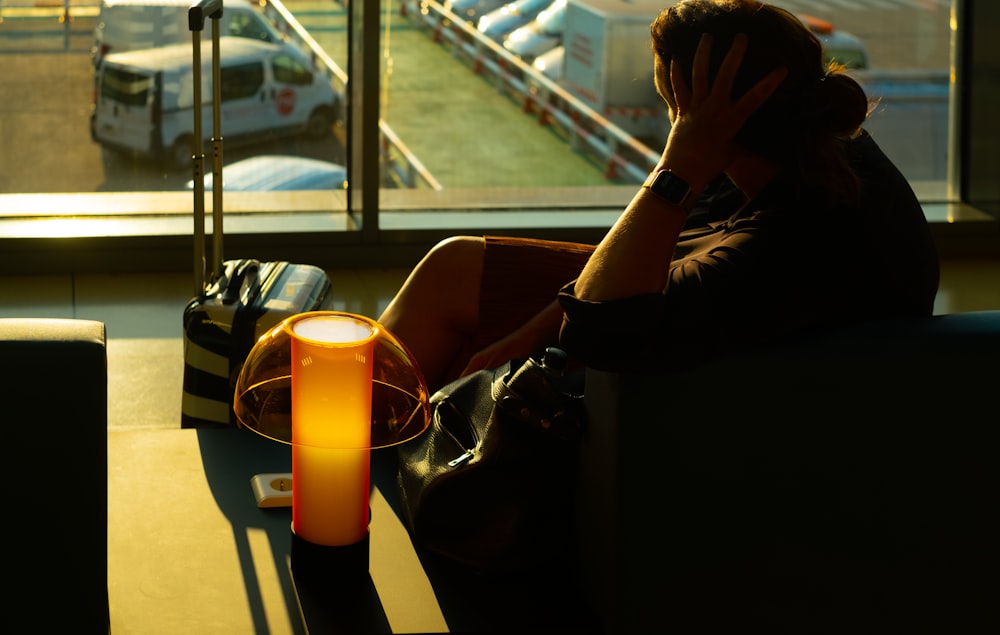 a person sitting on a couch in front of a window