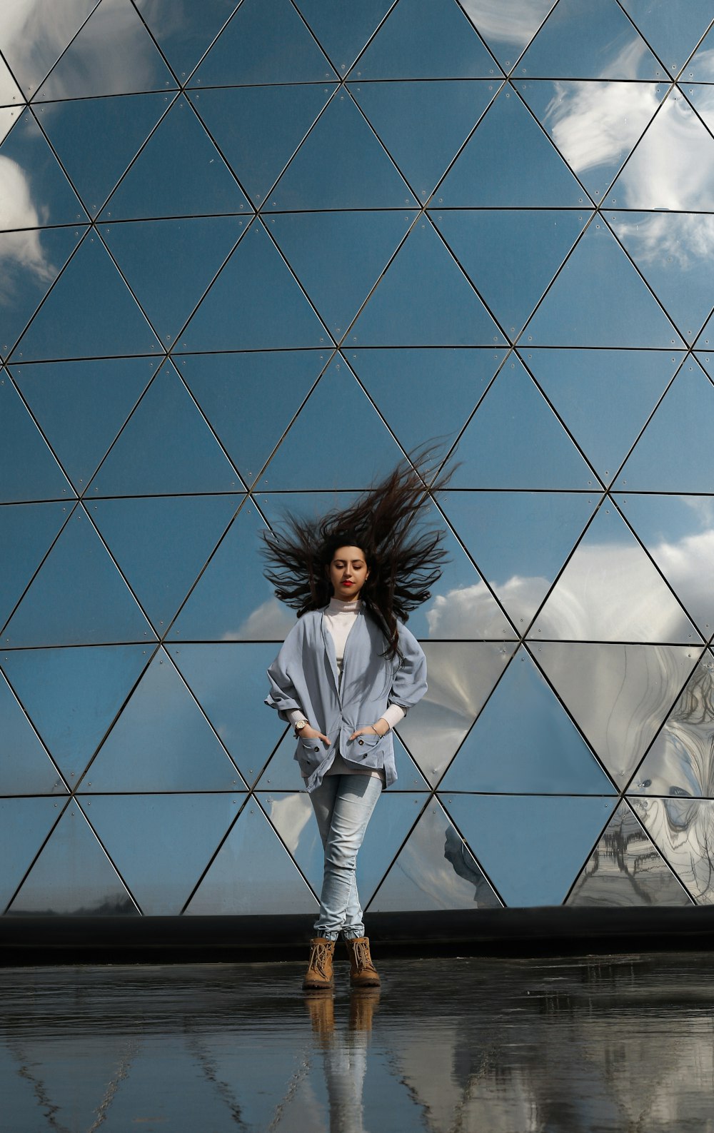 a woman with long hair standing in front of a building