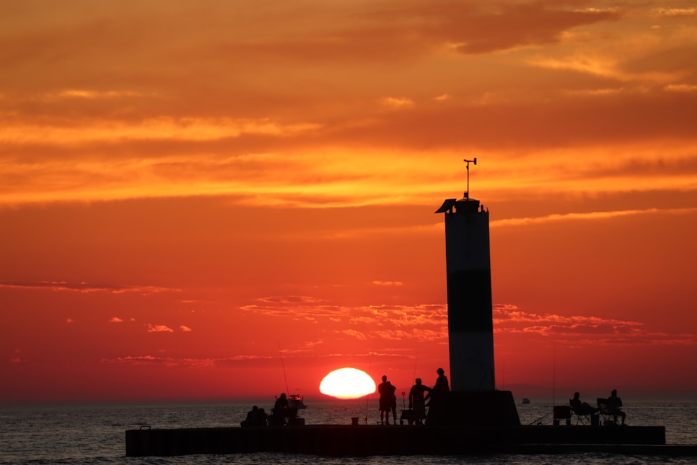 a group of people standing on top of a pier