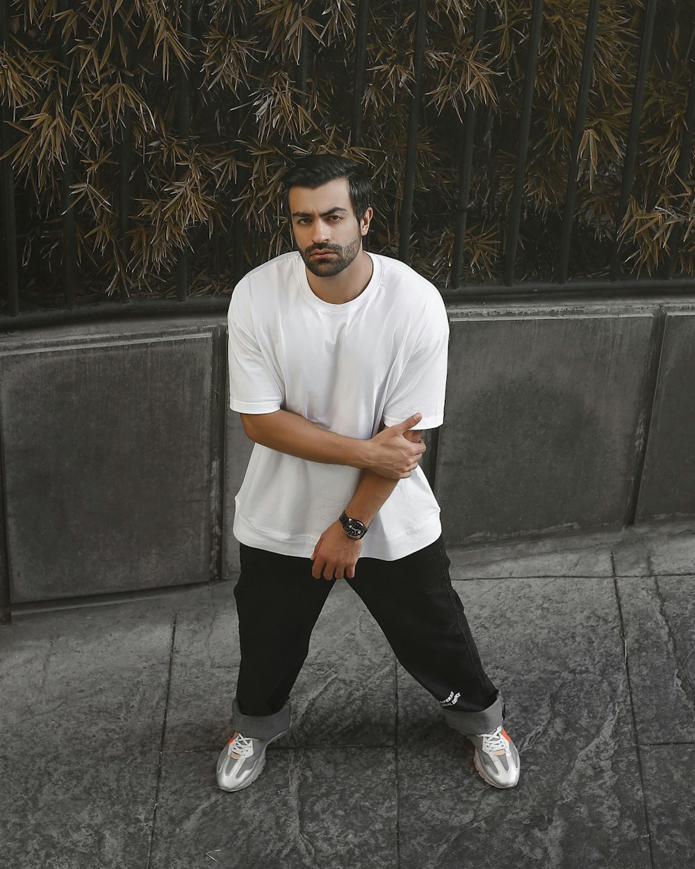 a man in white shirt and black pants posing for a picture