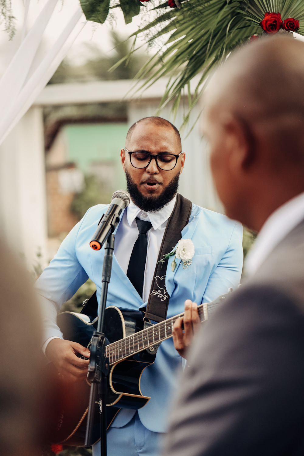 a man in a suit and tie playing a guitar