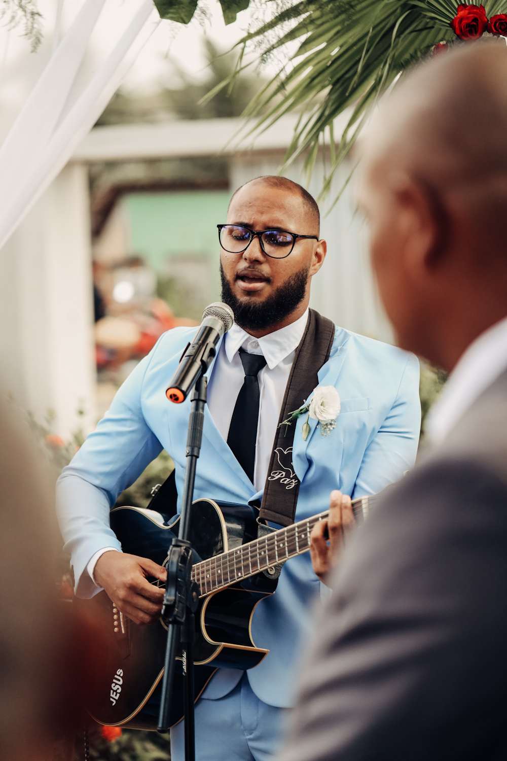 a man in a blue suit playing a guitar