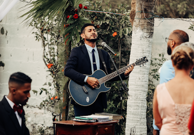 a man playing a guitar in front of a group of people