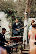 a man playing a guitar in front of a group of people