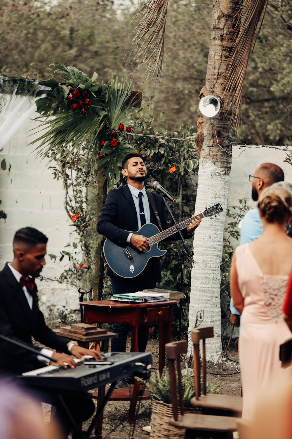 a man playing a guitar in front of a group of people