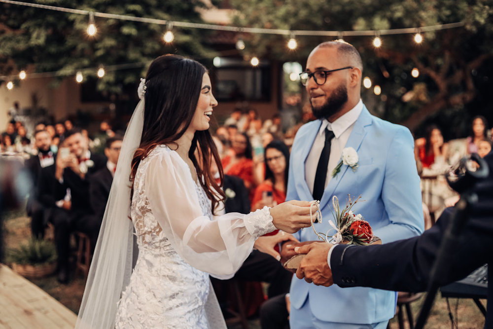 a bride and groom exchanging vows in front of a crowd of people