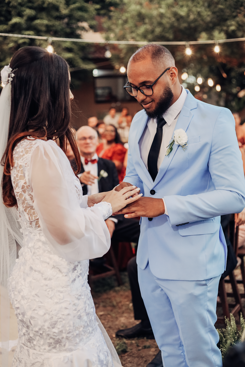 a bride and groom exchanging vows in front of an audience