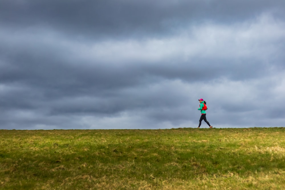 a person standing on top of a lush green field