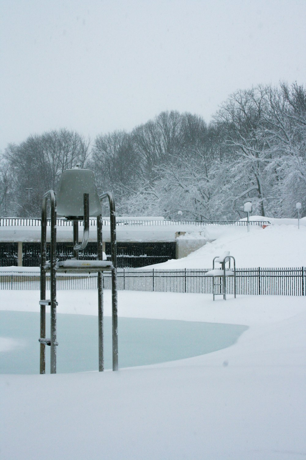 a park covered in snow next to a lake