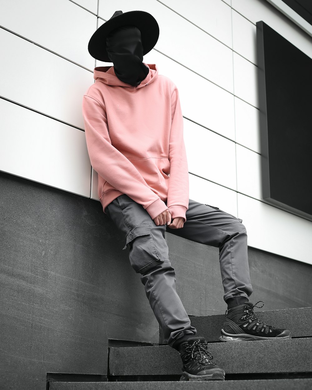 a man sitting on a step wearing a hat