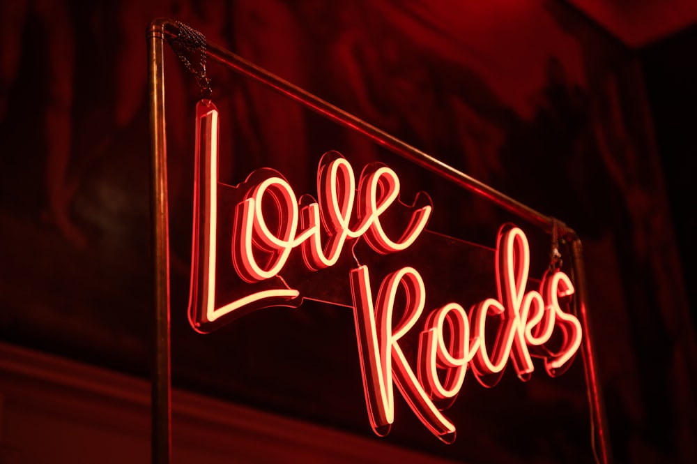 a neon sign that says love rocks on it