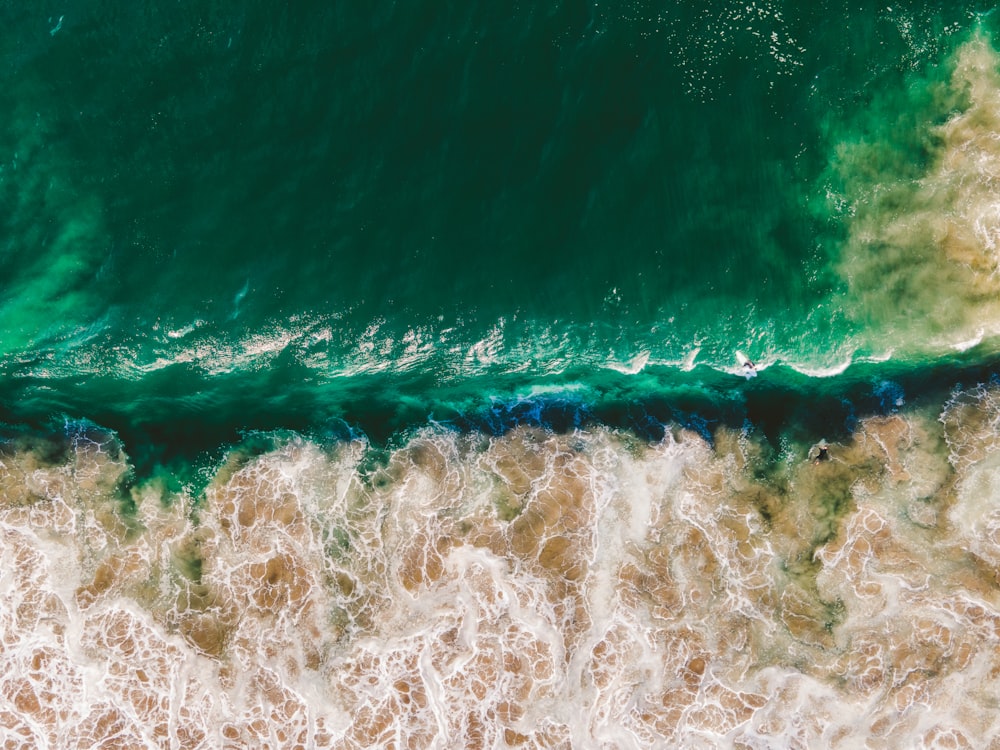 an aerial view of the ocean with waves