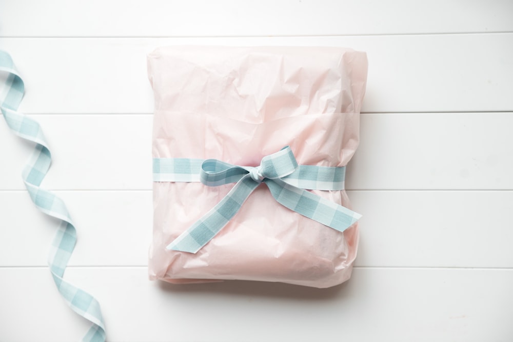 a wrapped present with a blue ribbon on a white background