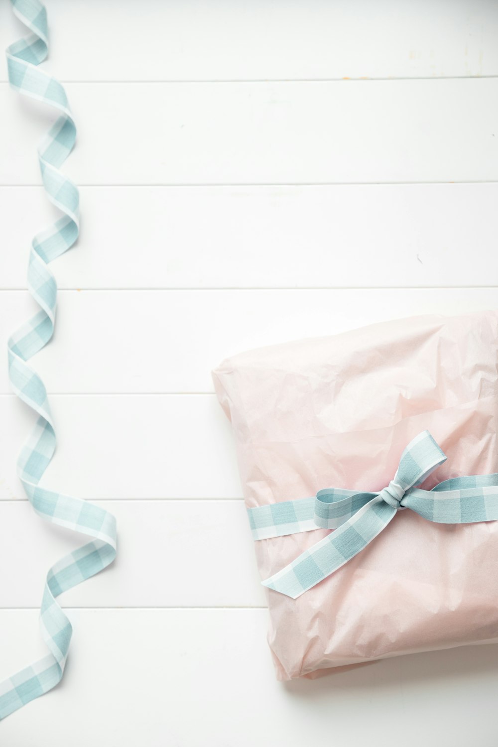 a pink wrapped present with a blue ribbon