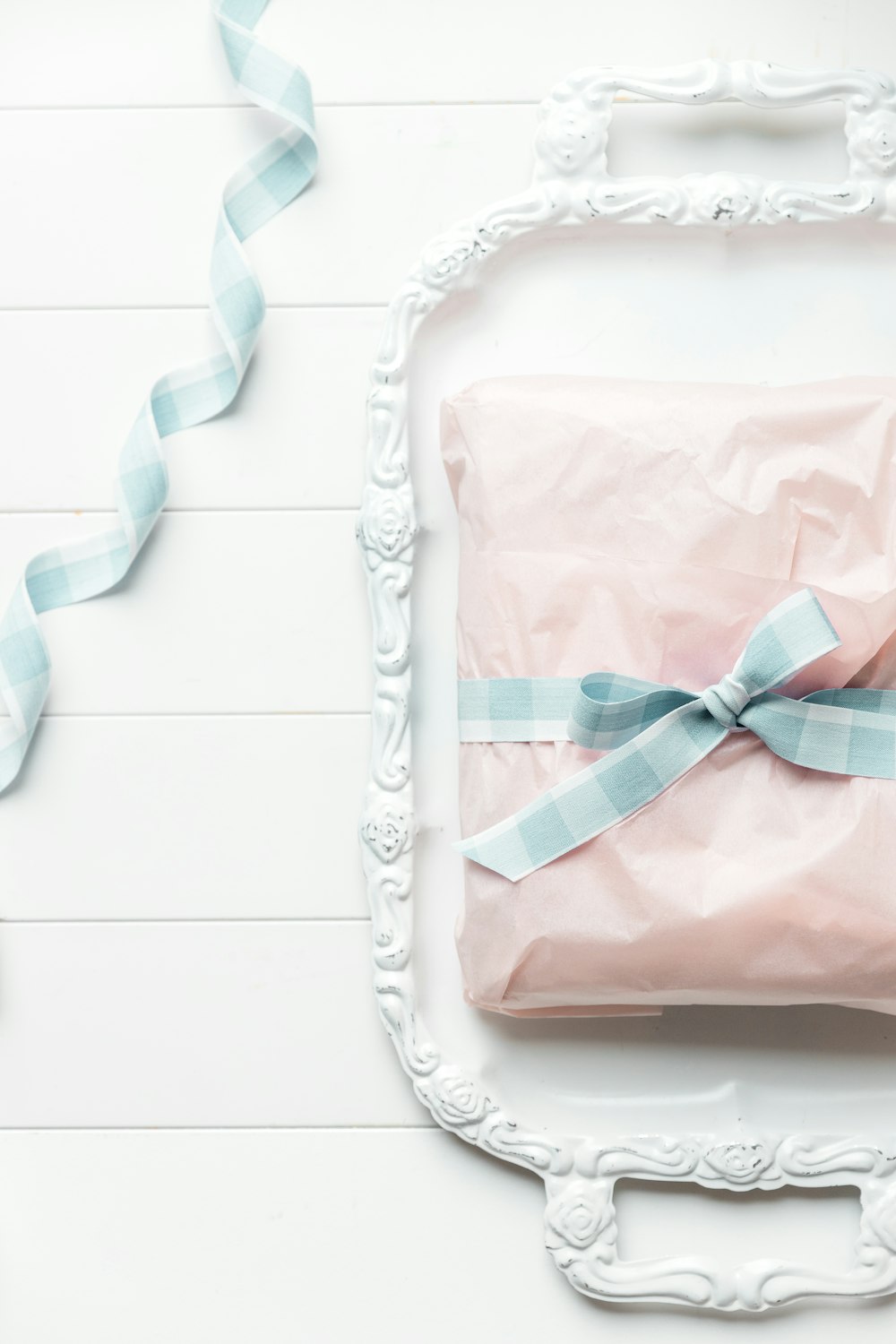 a pink gift wrapped in a light blue ribbon
