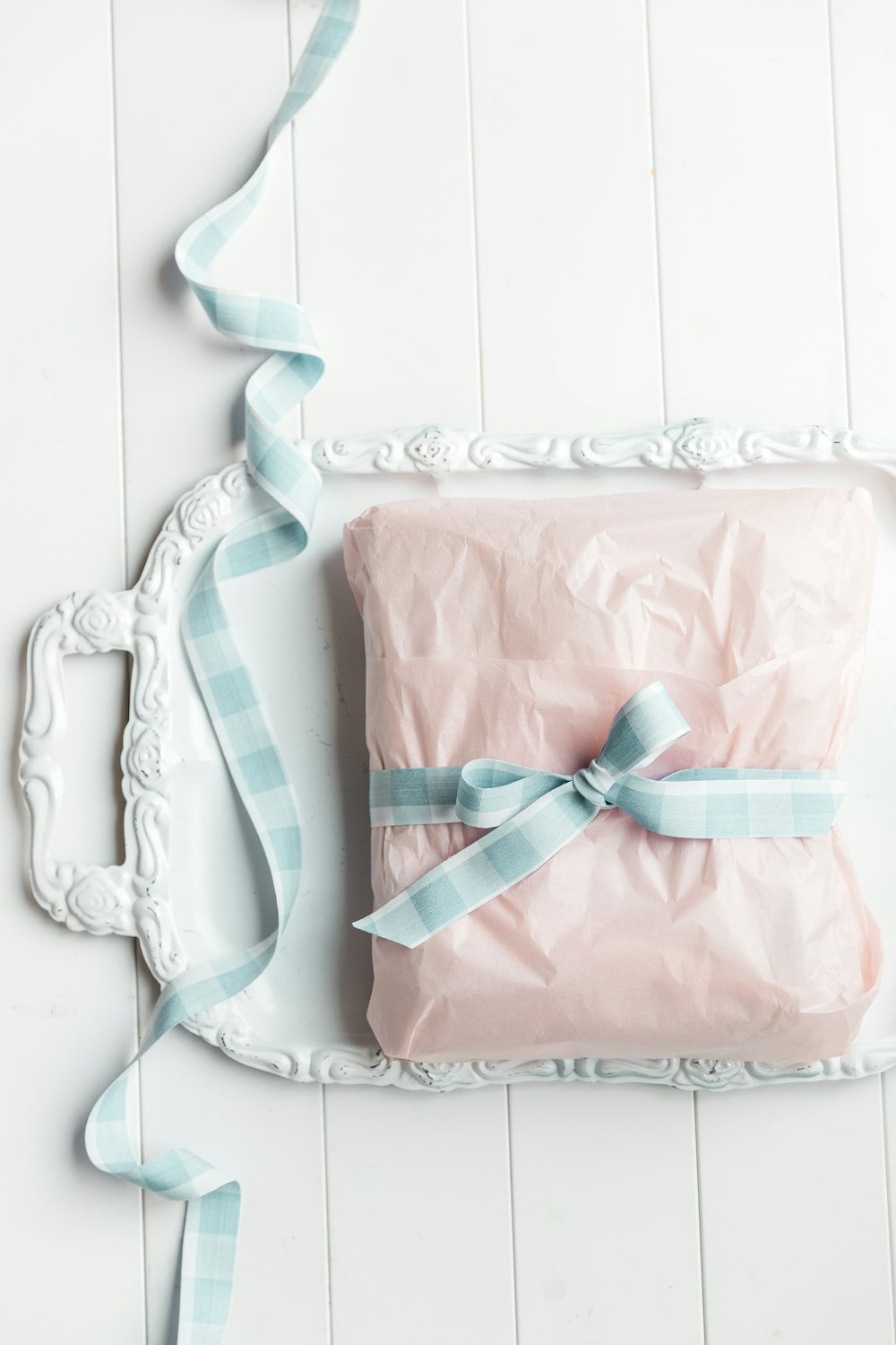 a wrapped present sitting on top of a white plate