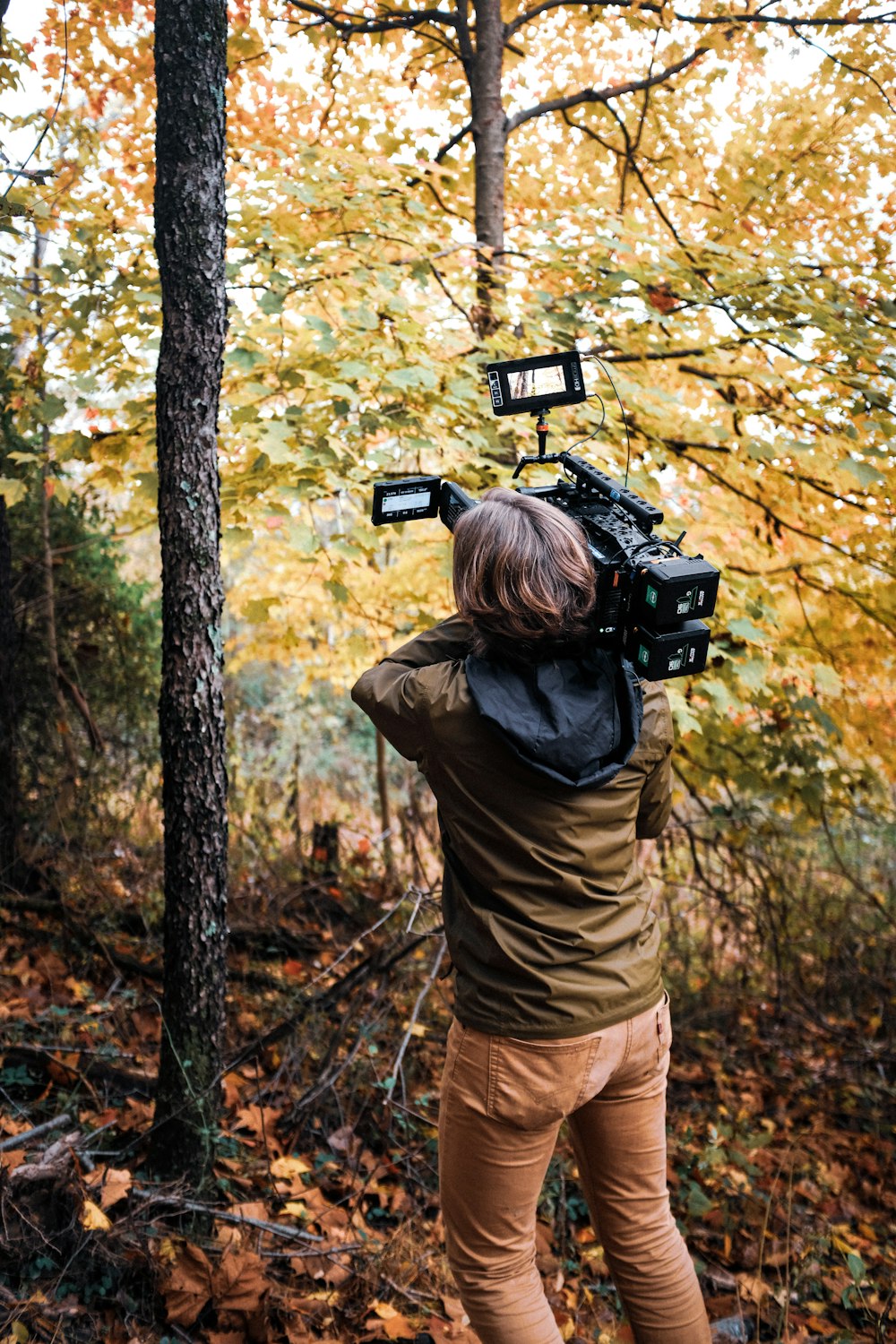 a person standing in the woods with a camera