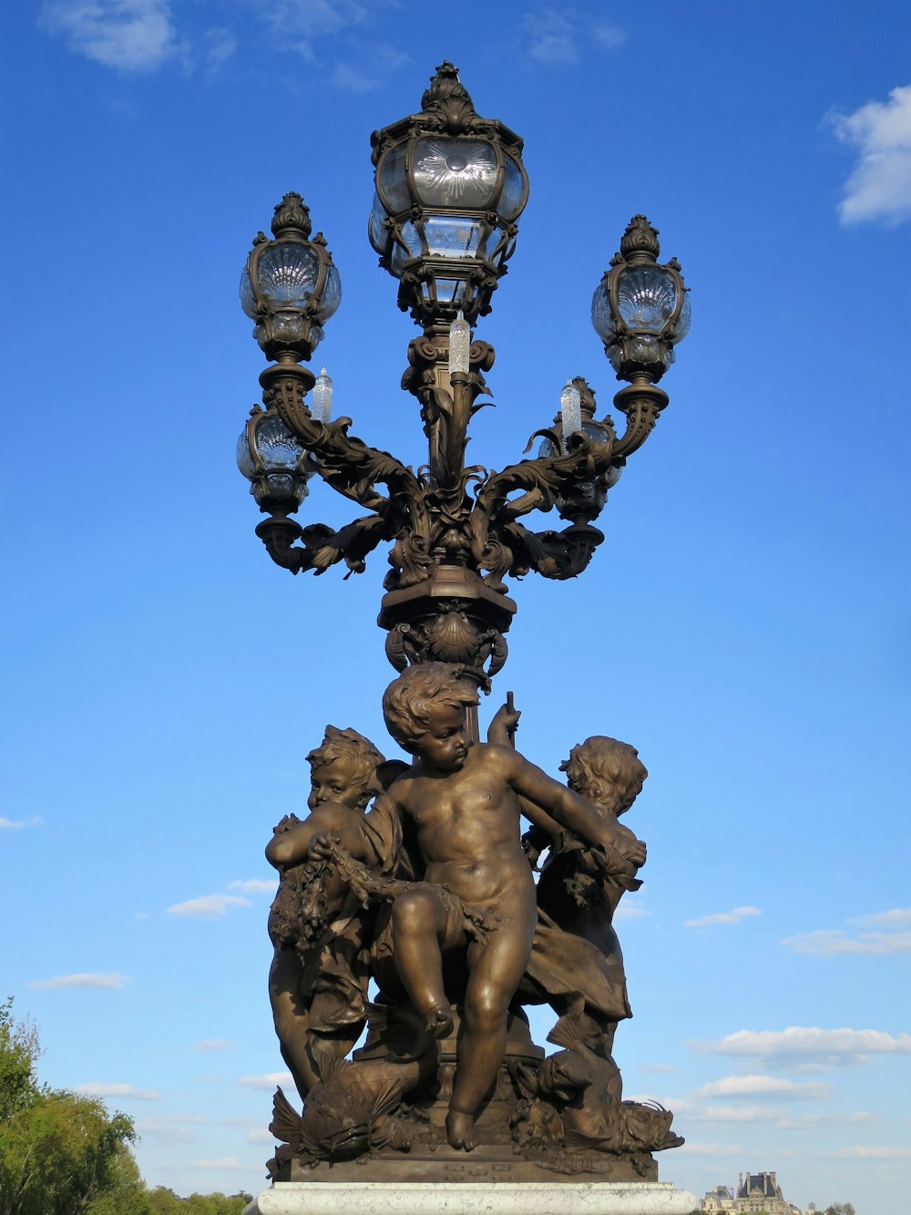 a statue of a boy holding a lamp post