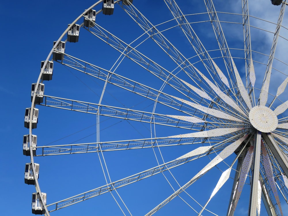 a ferris wheel against a blue sky with clouds