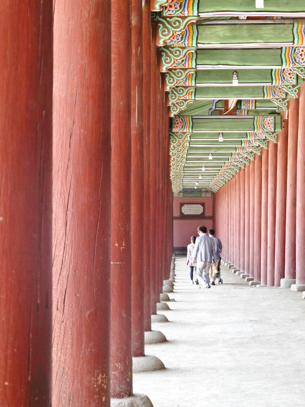 a couple of people that are walking under some columns