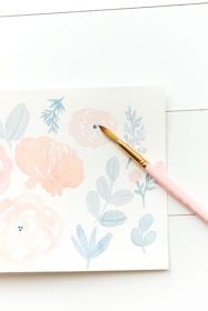 Close-up of delicate watercolor illustrations on pastel backgrounds.