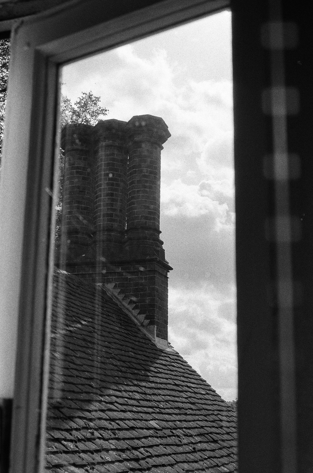 a black and white photo of a roof and a window