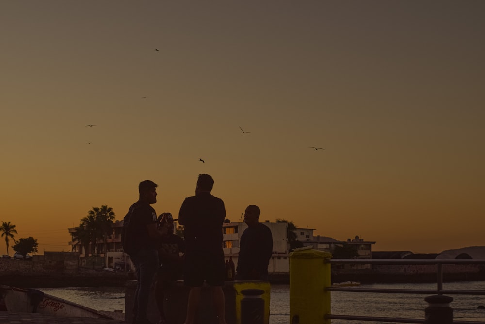 a group of people standing next to a body of water