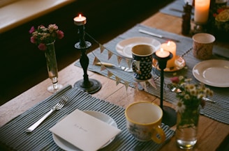 a table set for a meal with candles and plates