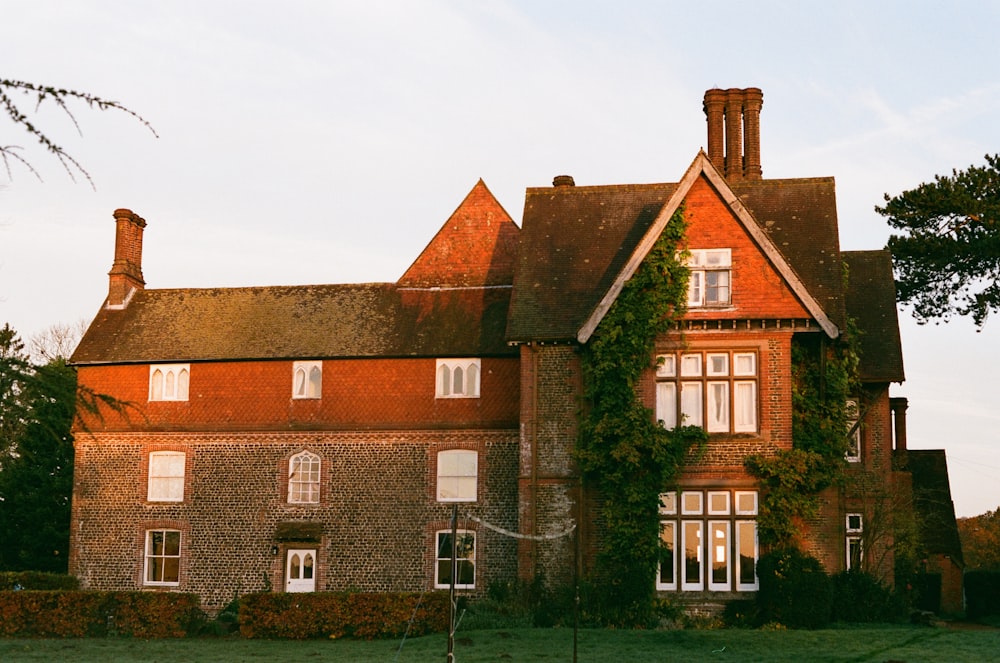 a large brick house with ivy growing on the side of it