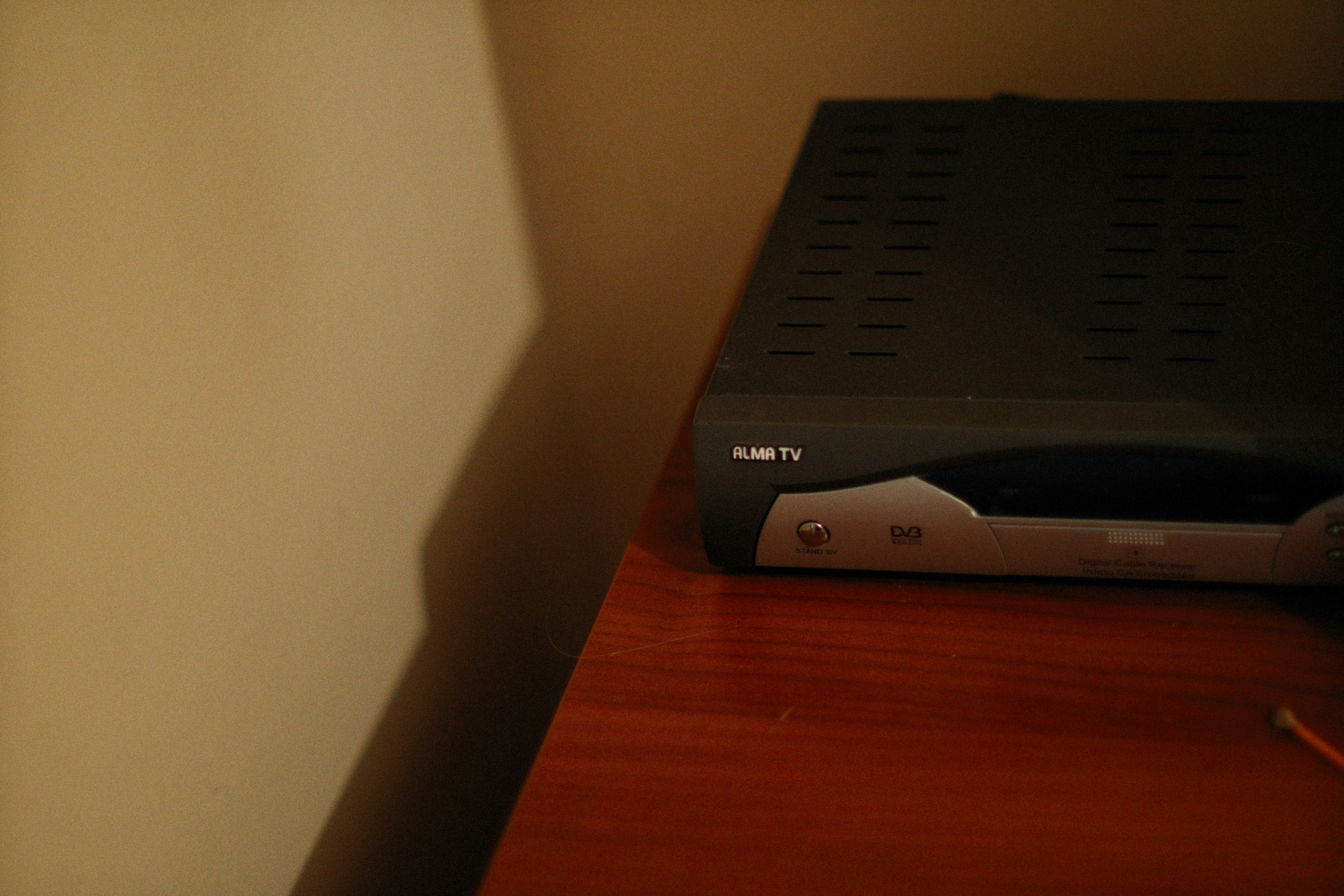 a black dvd player sitting on top of a wooden table