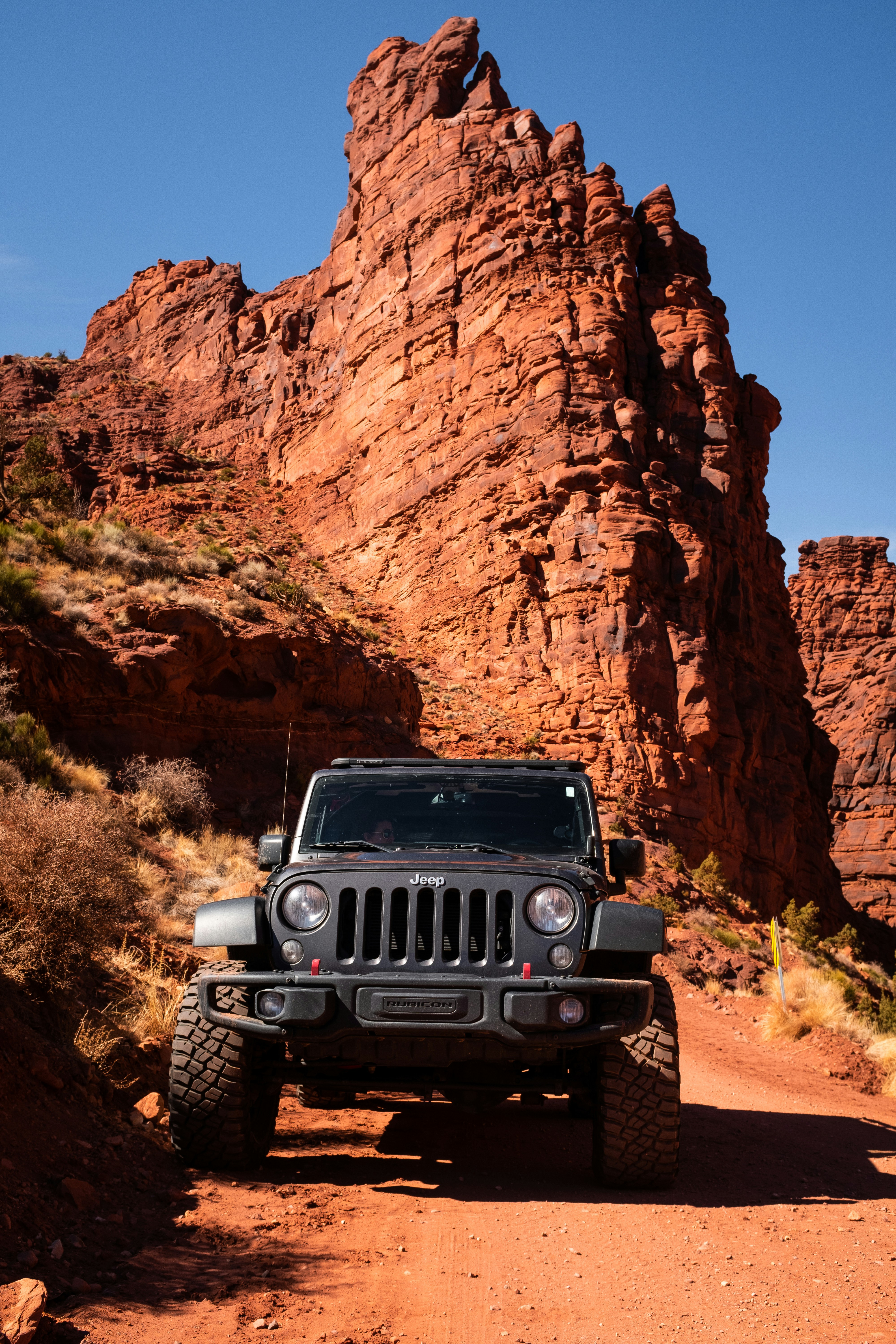 Ein Jeep fährt eine unbefestigte Straße in der Wüste hinunter